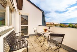 balkon ze stołem i krzesłami oraz oknem w obiekcie 4BR 3BATH BALCONY central Harry Potter penthouse w Pradze