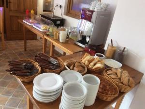 a table with white plates and baskets of bread at Penzion U Černého Potoka in Nová Lhota