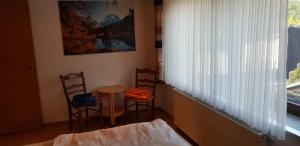 a room with two chairs and a table and a window at Ferienwohnung Haus Kapellenblick in Winterberg