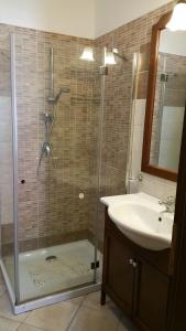 ein Badezimmer mit einer Glasdusche mit Waschbecken und Dusche in der Unterkunft Casa Vacanza Rosa in Pozzallo