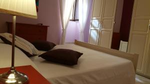 una camera da letto con un letto con una lampada e uno specchio di Casa Vacanza Rosa a Pozzallo