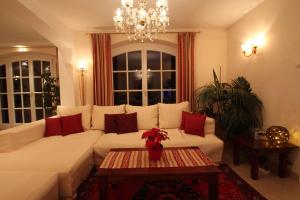 una sala de estar con un sofá blanco con almohadas rojas en Villa Wellness Homes, en Mötz