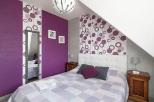 a purple bedroom with a bed and a mirror at Chez Marie et Jean François in Dol-de-Bretagne