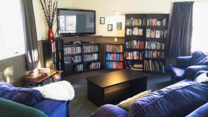 a living room with two couches and a tv at Zula Lodge in Wanaka