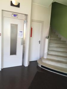 a staircase in a building with a white door and steps at Hotel d'Orléans in Angoulême