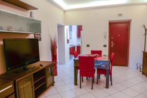 sala de estar con TV y mesa con sillas rojas en Anagnina Home, en Roma