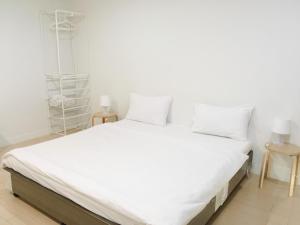 - un lit blanc avec des draps et des oreillers blancs dans l'établissement A-Port, à Lat Krabang