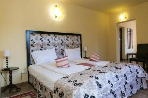 a bedroom with a large bed with white sheets and pink pillows at Hotel Transilvania in Sighişoara