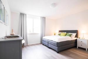 een witte slaapkamer met een bed en een raam bij ApartWehr Business&Ferien Apartment Grün in Wehr