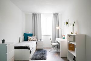 a white bedroom with a bed and a desk at ApartWehr Business&Ferien Apartment Grün in Wehr