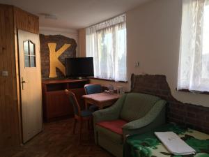 un soggiorno con tavolo, sedie e TV di uKazika a Orawka