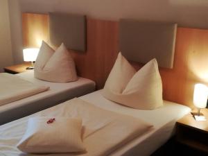 a hotel room with two beds with white pillows at Hotel Landgasthof Euringer in Oberstimm