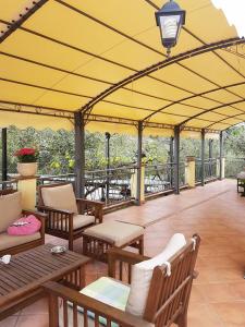een patio met stoelen en tafels en een geel dak bij Agriturismo Al Nido Degli Aironi in Sanremo