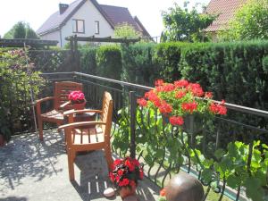 een tuin met 2 stoelen en bloemen op een patio bij U Jurka in Darłowo