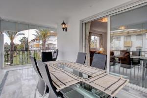 a dining room with a glass table and chairs at La Dame De Noche in Marbella