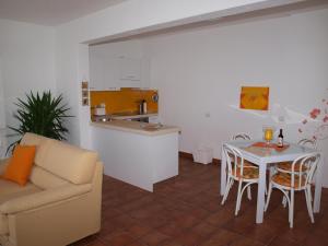 a living room with a couch and a table and a kitchen at Villa Banfi in Lavena Ponte Tresa