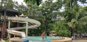 un tobogán de agua en una piscina de un complejo turístico en The Park Land Bangna by Nudda, en Bangkok