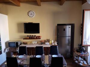 ソルソにあるB&B L'Antico Porticoのテーブル、椅子、冷蔵庫が備わる客室です。