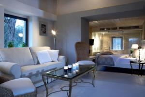 ein Wohnzimmer mit Sofa und Bett in der Unterkunft Torri E Merli Hotel by GHH in Lákka