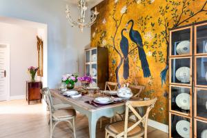 a dining room with a table and a peacock wallpaper at Palacio Bucarelli in Seville