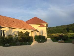 une maison jaune avec un toit rouge et une allée dans l'établissement La Raimbaudière, à Guigneville