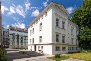 een wit gebouw voor sommige gebouwen bij Yourplace Biskupia Old Town Apartments in Krakau