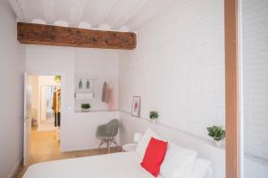 a bedroom with white walls and a bed with red pillows at BALCON ENCIERRO! - El Mirador de la Cuesta de Santo Domingo in Pamplona