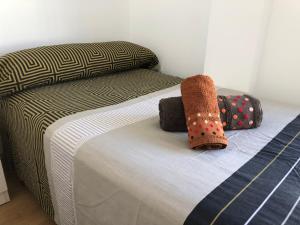 a bed with two pillows on it in a room at Apartamento Estrella Rural in Lumpiaque