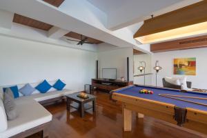 ein Wohnzimmer mit einem Billardtisch und einem Sofa in der Unterkunft Vichuda Hills in Layan Beach