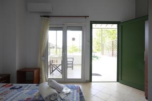 a bedroom with a bed and a sliding glass door at Istira in Possidi