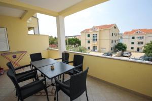 a balcony with a table and chairs and a view at Apartmani Vrtlici Zdenka in Stara Novalja