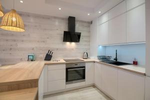 a kitchen with white cabinets and a stove at Apartament Rybakówka in Kołobrzeg