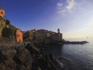 a group of buildings on a cliff next to the water at Casa della nonna Filò in Beverino