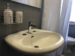 a white sink in a bathroom with a toilet at Casa della nonna Filò in Beverino