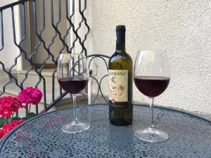 a bottle of wine and two glasses on a table at Casa della nonna Filò in Beverino
