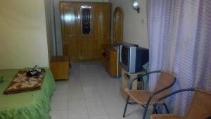 Cette petite chambre dispose d'une télévision, d'une table et de chaises. dans l'établissement Melissa Palace Hotel and Karaoke, à Parapat