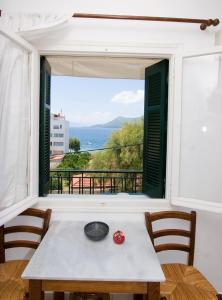 una mesa con vistas al océano desde una ventana en Soile Georgia, en Loutra Edipsou