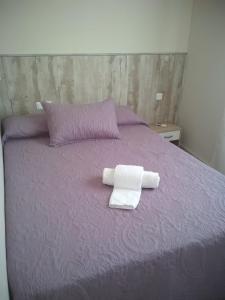 モハカルにあるApartamento Rey Alabezの紫色のベッド(折りたたみ式タオル2枚付)