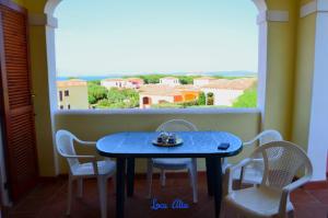 a blue table and chairs in a room with a window at da mario e maria in Aglientu