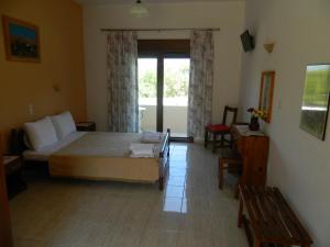 a bedroom with a bed and a table and a window at Asteri Studios in Skiathos Town