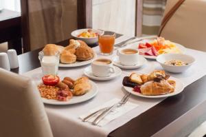 a table topped with plates of breakfast foods and drinks at Alexandra Hotel in St. Julianʼs