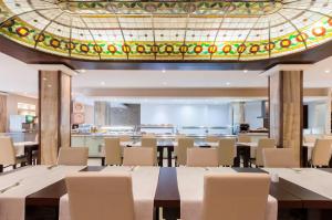 une salle à manger avec des tables et des chaises et un plafond dans l'établissement Alexandra Hotel, à San Ġiljan