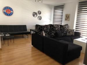 a living room with a black couch and a table at Apartamento Estrella Rural in Lumpiaque