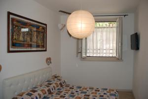 a bedroom with a bed and a lamp and a window at Casa Anita in Limone sul Garda