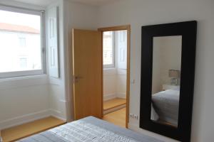 um espelho num quarto com uma cama e uma janela em Arco de Almedina Boutique em Coimbra