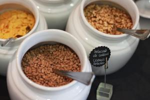 a table with three bowls of food and nuts at Real Marina Hotel & Spa in Olhão