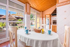 a table with a white table cloth on it in a room with windows at La torre Casa rural in Fuente de Piedra