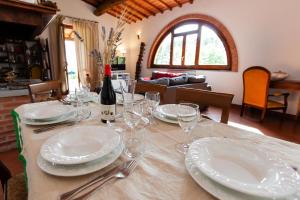 a table with plates and glasses and a bottle of wine at La Casa in Toscana in Cortona