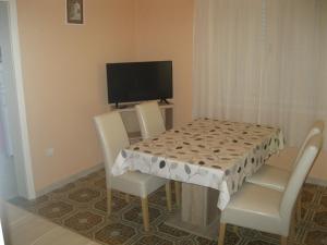 stół jadalny z 2 krzesłami i telewizor w obiekcie Apartments Radić w Trogirze