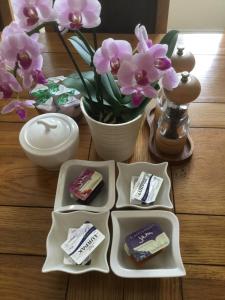 a table with three containers of soap and a vase with flowers at Moon House in Oxford